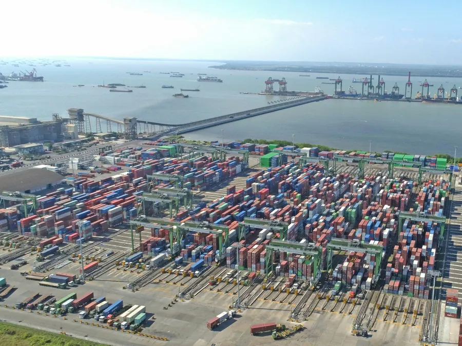 Aerial view of a busy container port with cranes and cargo ships